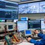 Technician testing telemetry equipment with diagnostic tools in industrial control room