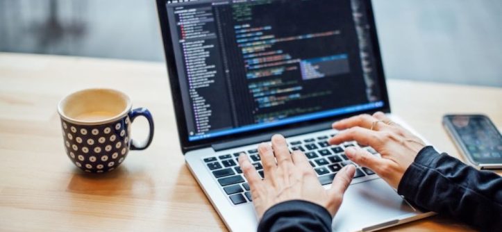 Student in California starting a computer engineering career with laptop, coding screen, and circuit board project.