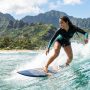 Surfer wearing waterproof earbuds on a scenic Hawaiian wave.
